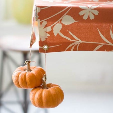 DIY fall decoration with little pumpkins as tablecloth weights